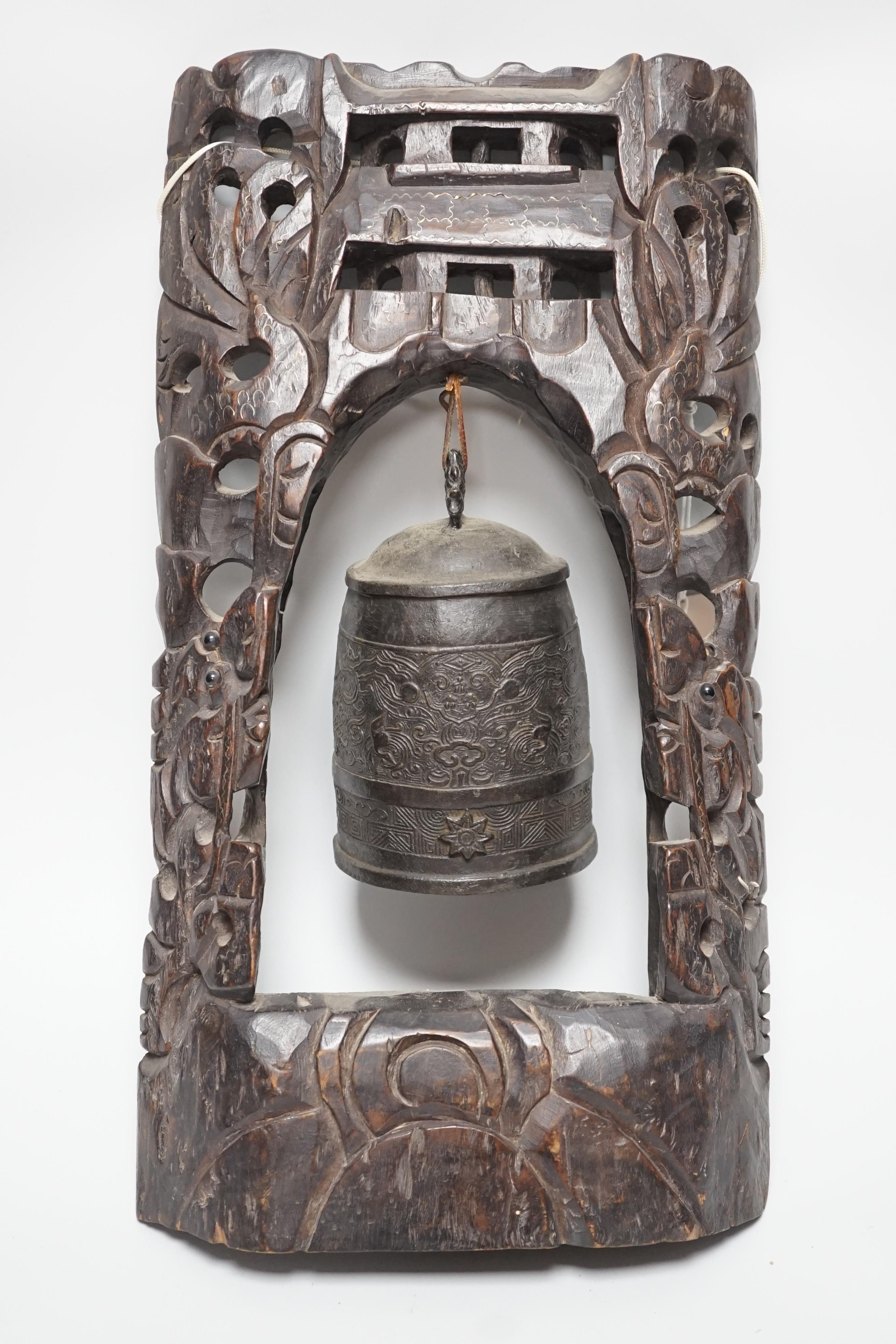 A Chinese bronze bell with wire inlaid carved hardwood stand, 44cm